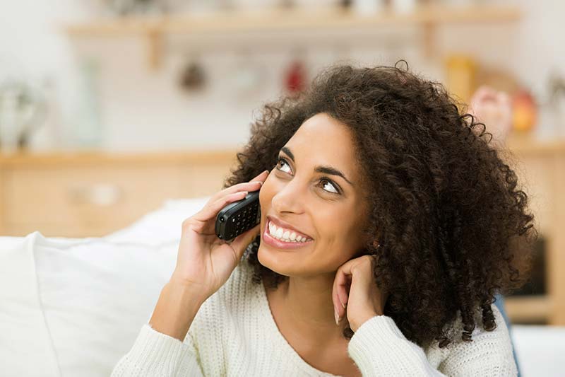 Woman smiling while on the phone with one of our certified home inspectors