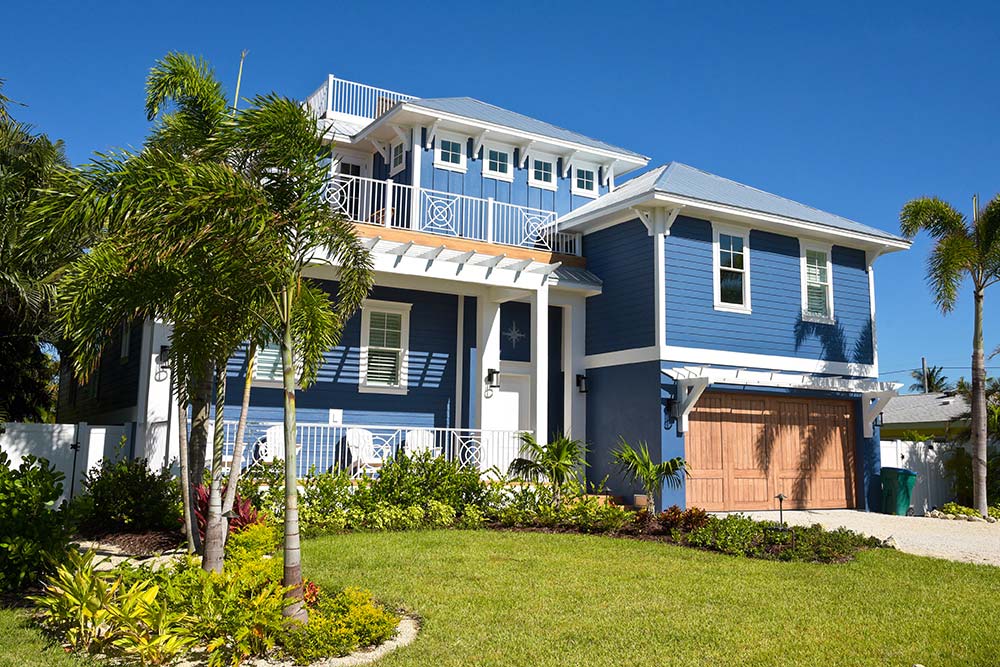 New construction house surrounded by tropical landscaping seen while home inspection services are being provided