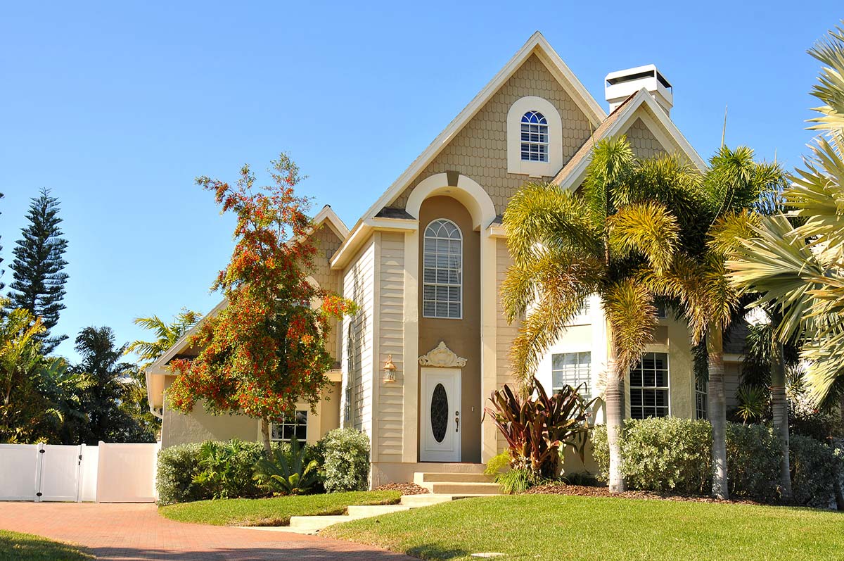 Beautiful house surrounded by palm trees seen while home inspection services are being preformed